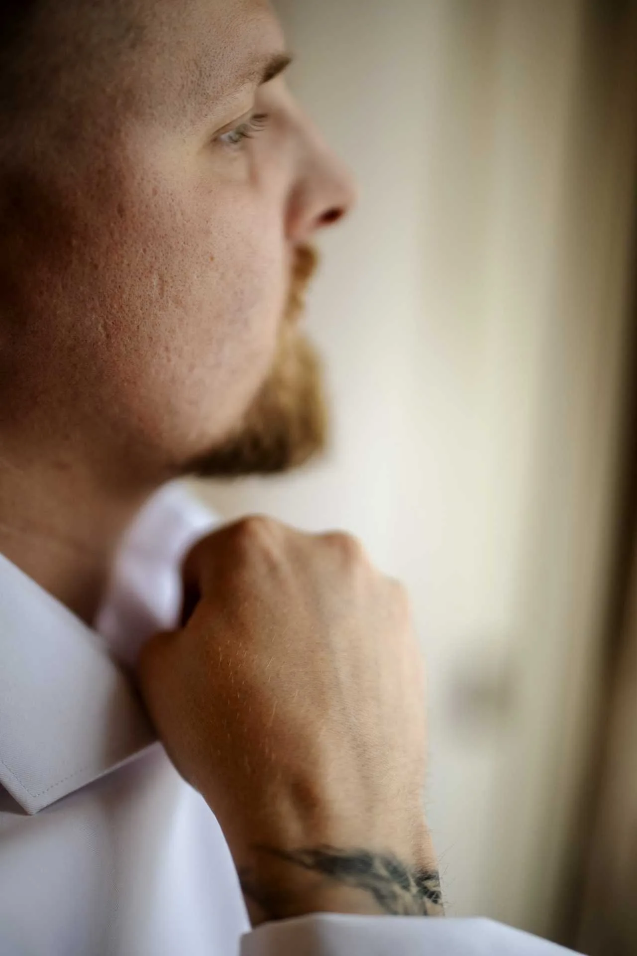 Daniel si zapína košeľu